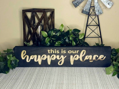 Personalized happy place sign hanging in a vacation home entryway.
