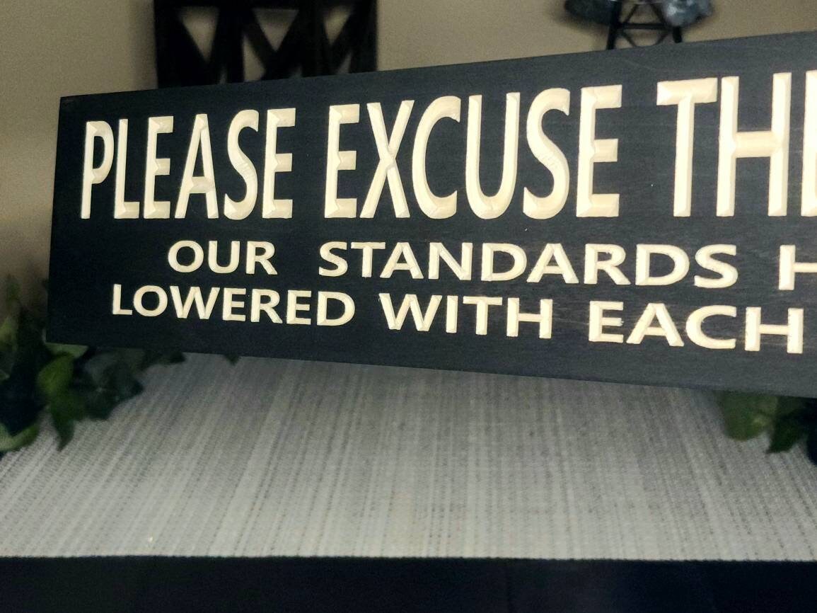 Playful home sign with a relatable parenting quote for busy households.
