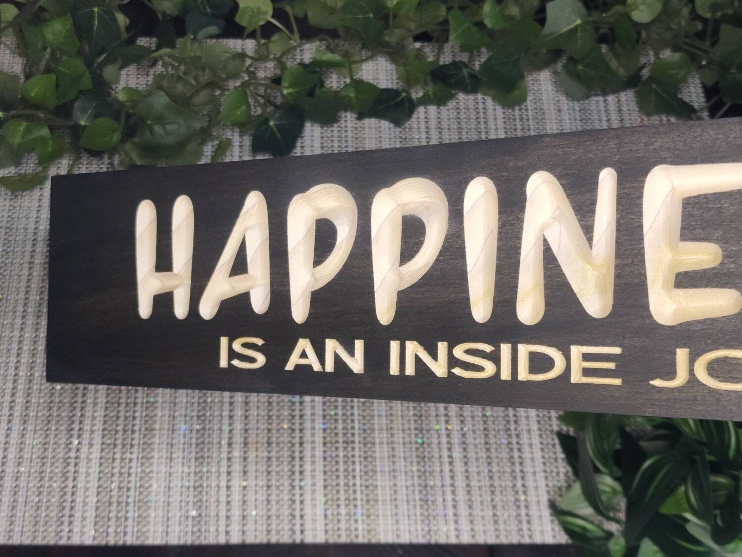Positive affirmation wall art featuring a wooden happiness quote sign.
