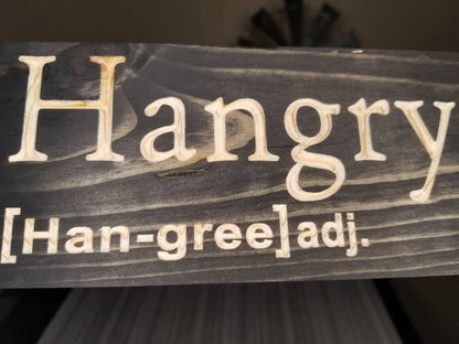 Quirky hangry definition wall decor for foodie-themed kitchen spaces.
