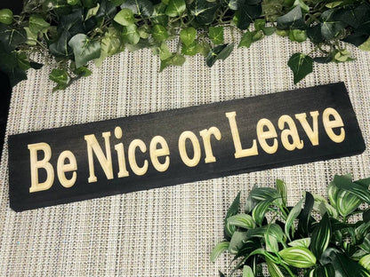 Rustic "Be Nice or Leave" wood sign displayed in a farmhouse-style entryway.

