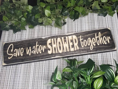 Rustic bathroom decor sign with a humorous water conservation message.
