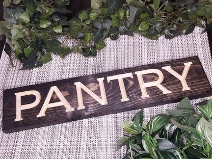 Rustic wooden "PANTRY" sign displayed on a farmhouse pantry door.

