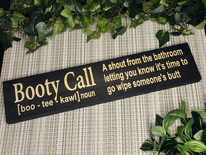 Rustic wooden bathroom sign reading Booty Call - A shout from the bathroom letting you know it's time to go wipe someone's butt in a cozy family bathroom.
