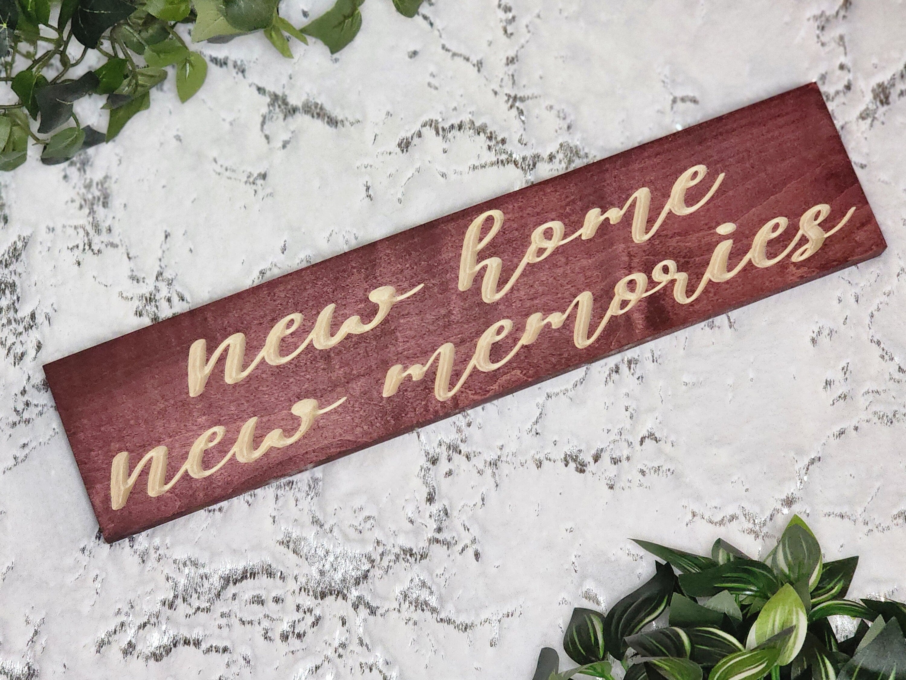 Rustic wooden sign reading New Home, New Memories displayed in a cozy entryway.
