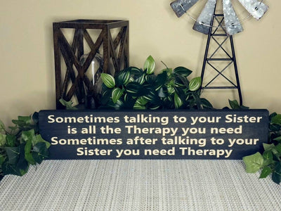 Rustic wooden sister sign with sentimental and humorous text.
