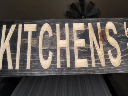 Sentimental wooden kitchen sign adding warmth to a family gathering space.
