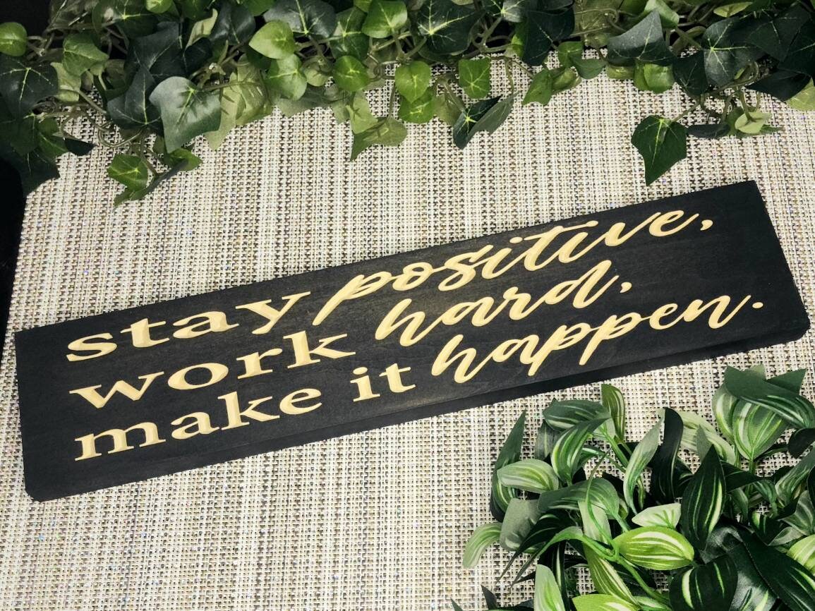Stay Positive, Work Hard, Make It Happen wooden sign styled in a modern home office.

