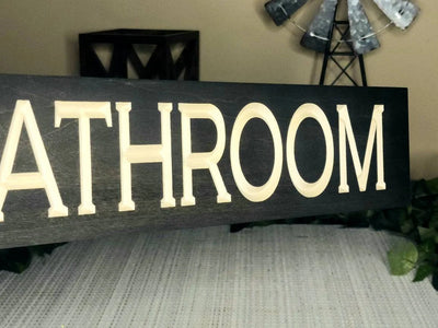 Stylish bathroom nameplate placed in an Airbnb or hotel restroom.
