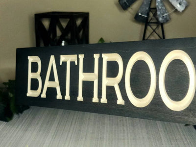 Vintage-style bathroom wall sign displayed in a guest bathroom.
