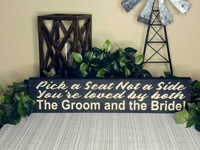 Wedding ceremony aisle decor with unity-themed wooden sign for guests.
