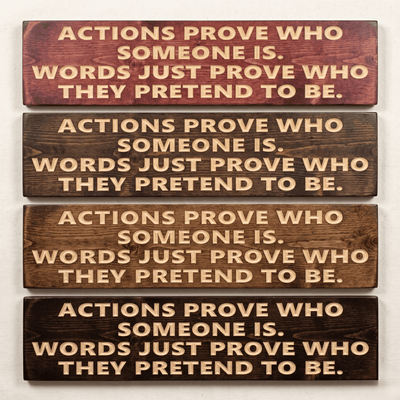 Motivational wood sign reading "Actions Prove Who Someone Is, Words Just Prove Who They Pretend to Be" shown in four stain finish options including cabernet, dark walnut, early American, and ebony — CNC carved rustic wall art from Bluegrass Gifts.