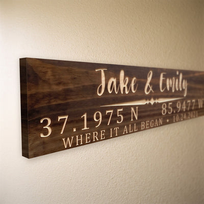 Close-up of the carved letters on the Jake & Emily sign, natural pine inside the cuts against the stained grain