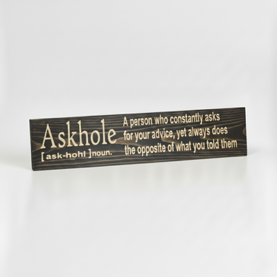 Angled view of the handcrafted Askhole definition wood sign, showing the high-contrast natural wood grain against a dark finish.