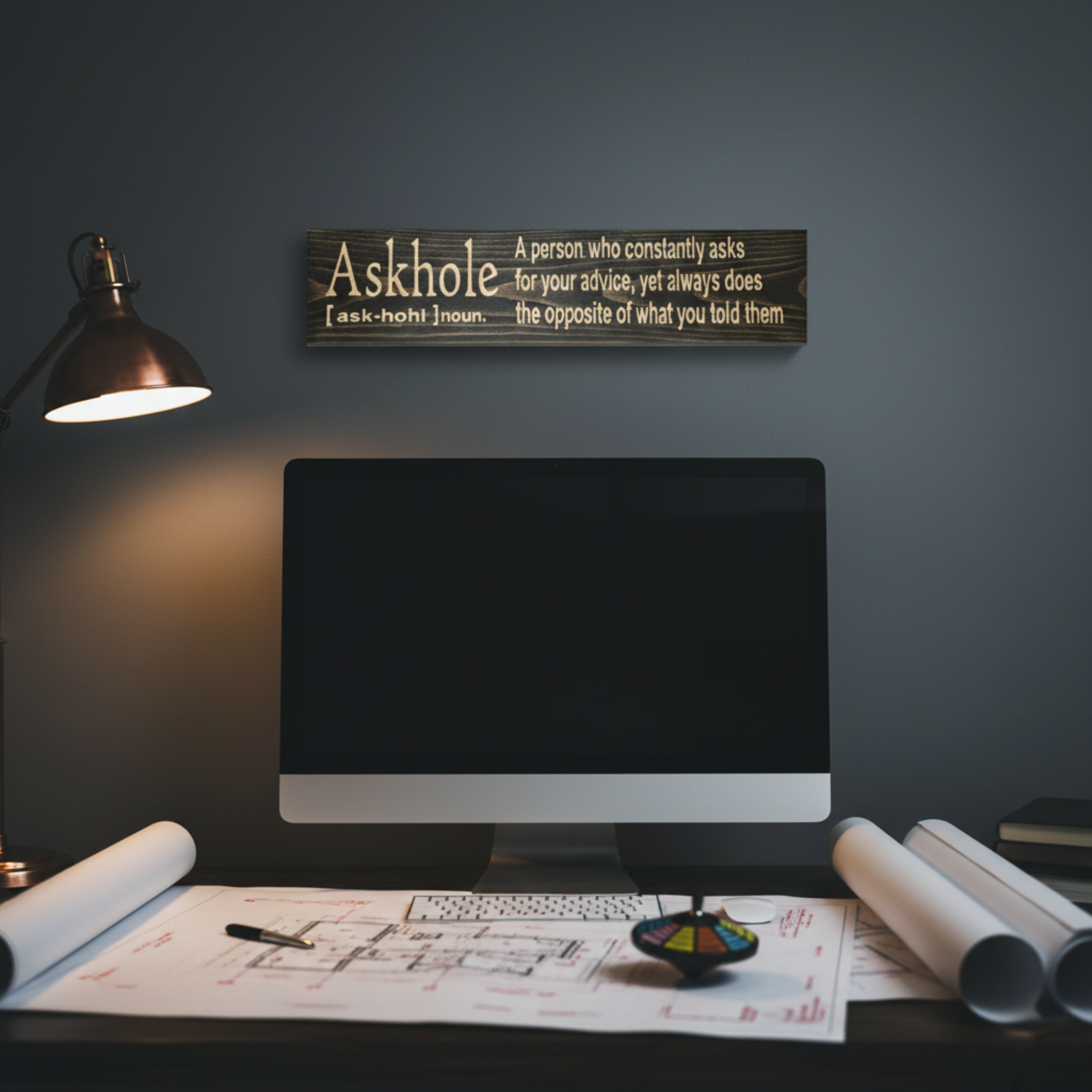 Funny Askhole definition wood sign mounted on a dark office wall above a computer desk as a humorous workspace accent.