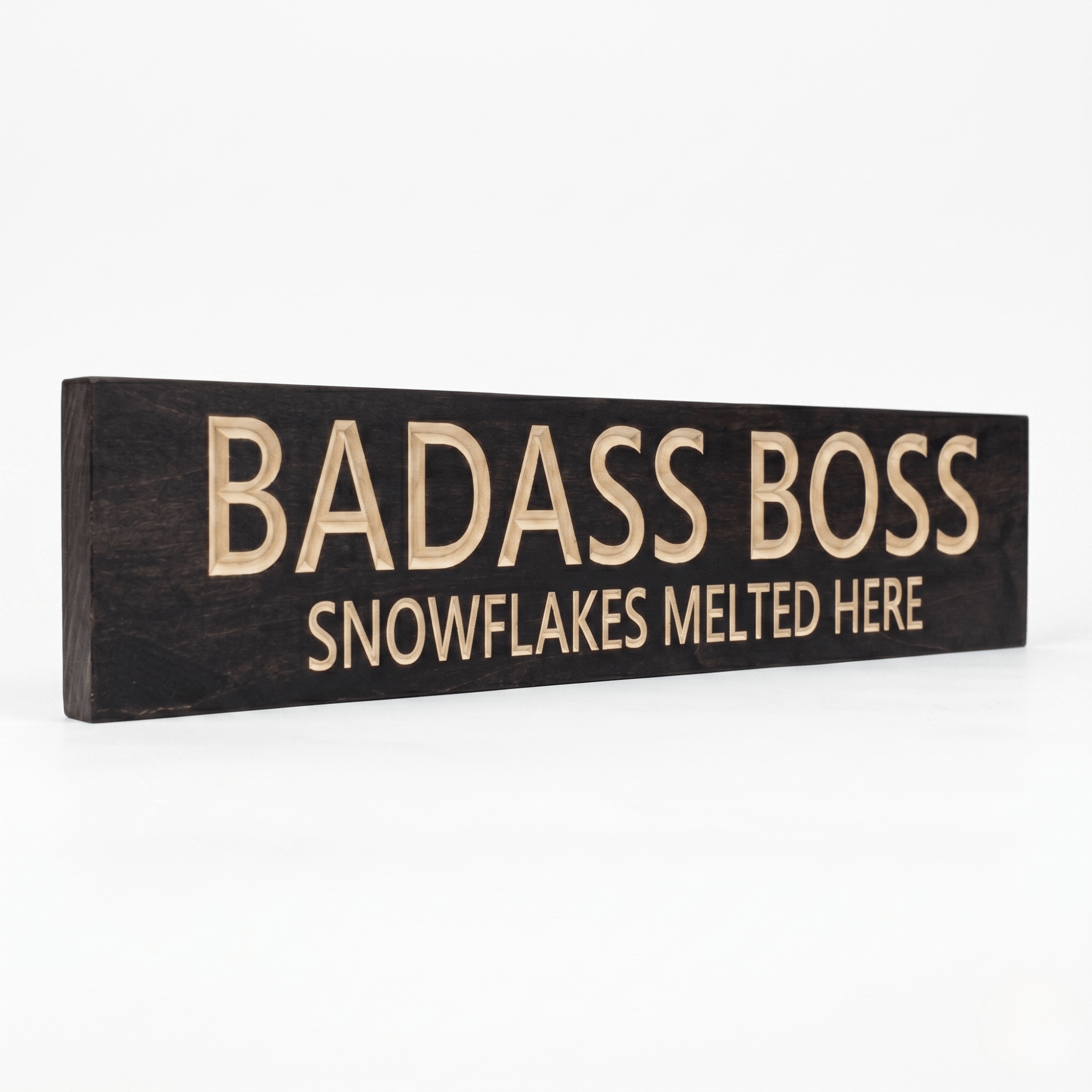 Angled view of the solid wood Badass Boss motivational office sign with carved lettering.