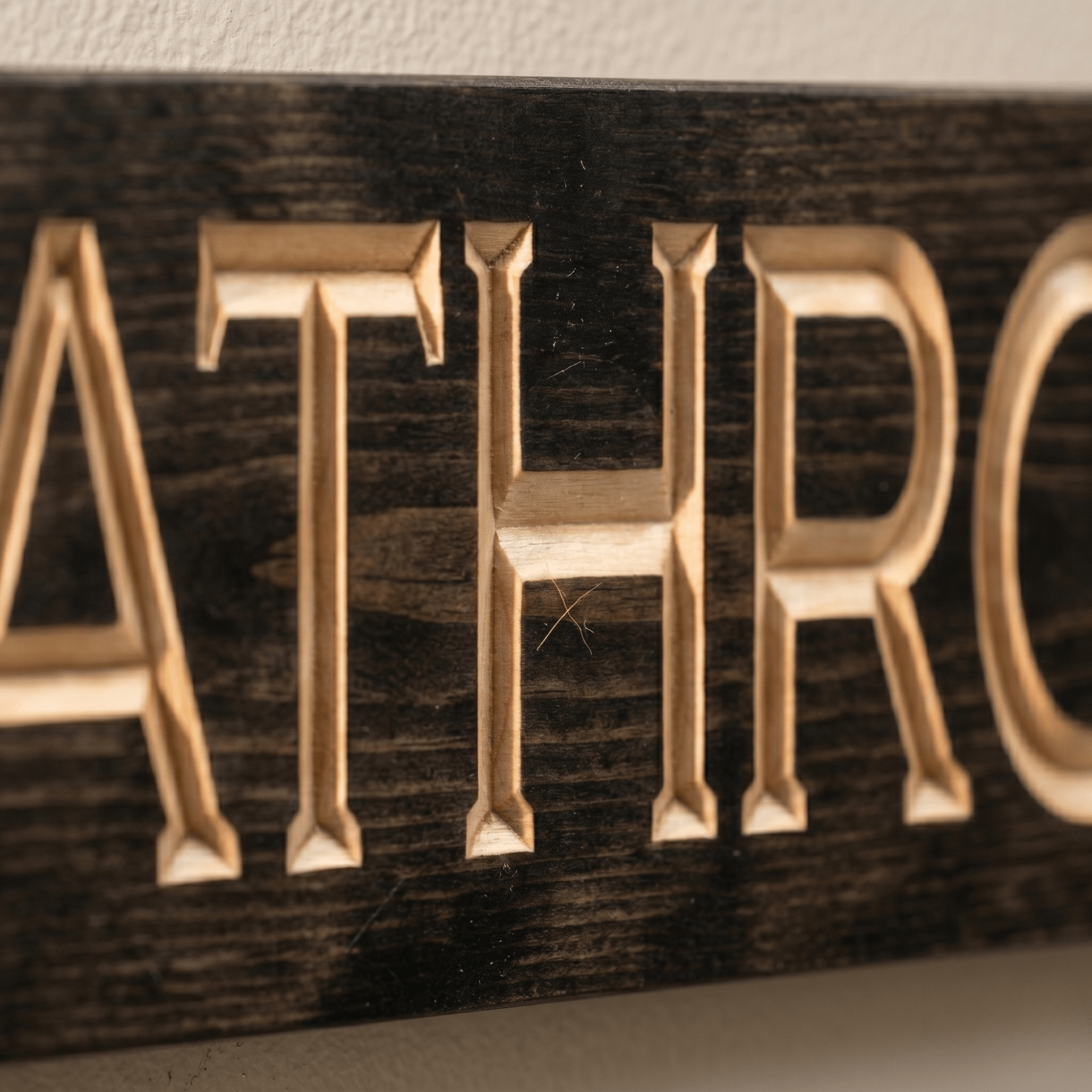 Macro close-up of CNC carved ATHRO letters on the Bathroom wood sign revealing real pine grain, hand-finished depth, and authentic Kentucky craftsmanship.