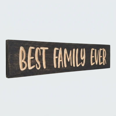 The dark stained Best Family Ever Sign, carved from pine or poplar, is angled against a plain white background