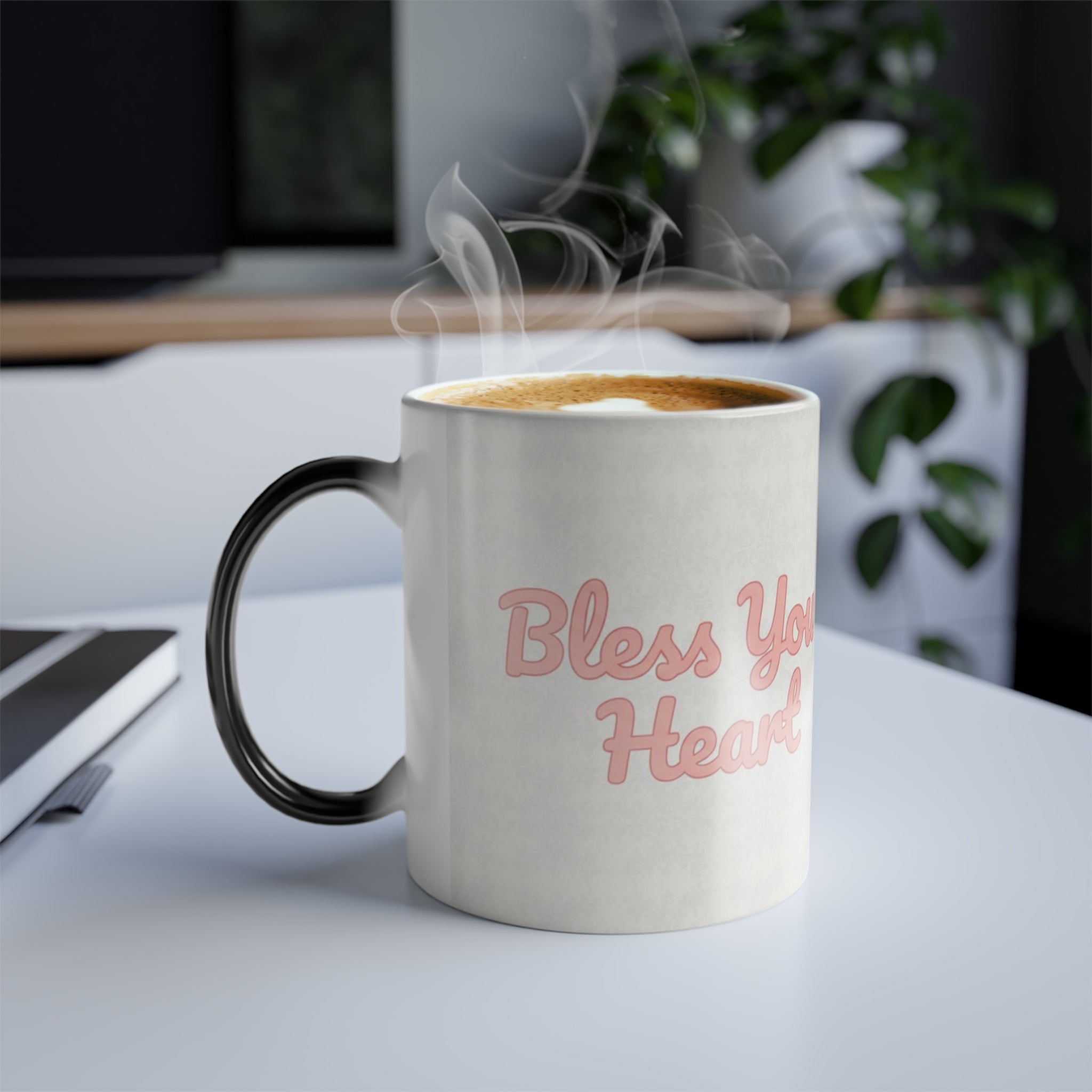 Steaming Bless Your Heart color changing magic mug on modern white desk, funny southern coffee cup from Bluegrass Gifts.