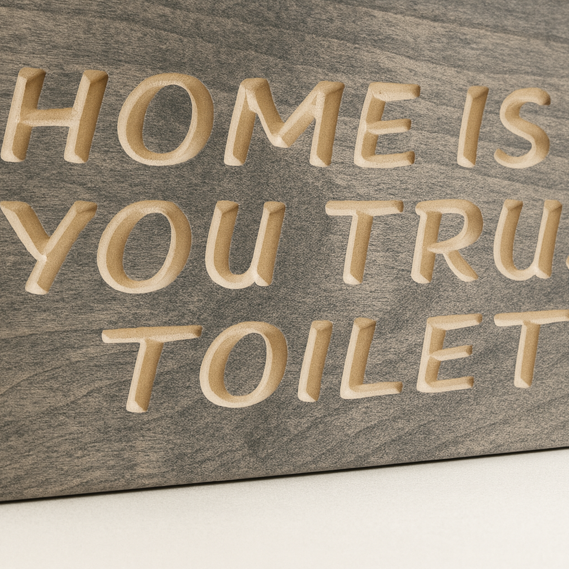 Close-up carved wooden bathroom sign – detailed engraving of “Home Is Where You Trust the Toilet Seat.”