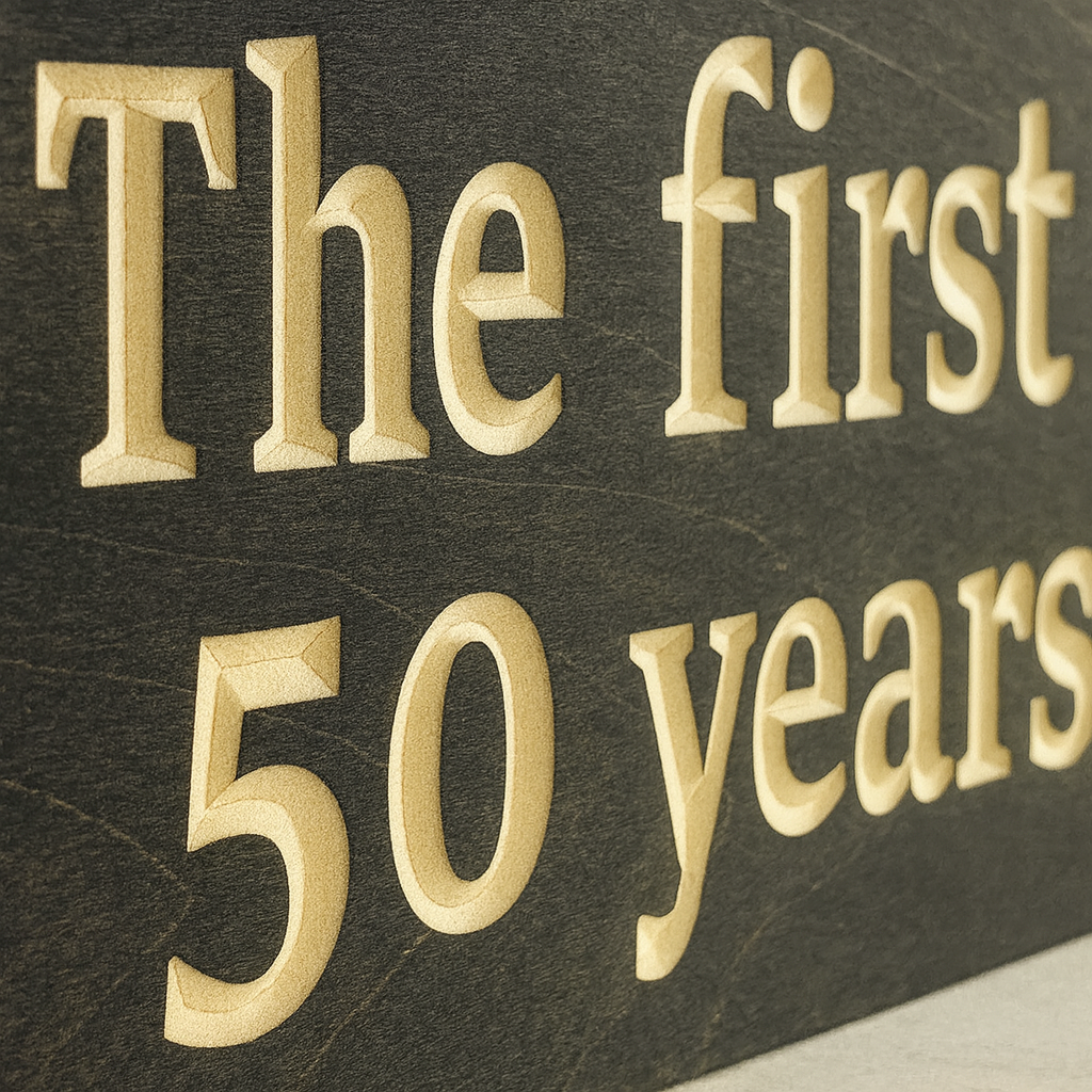 Close-up detail of engraved wooden anniversary sign showing carved letters.
