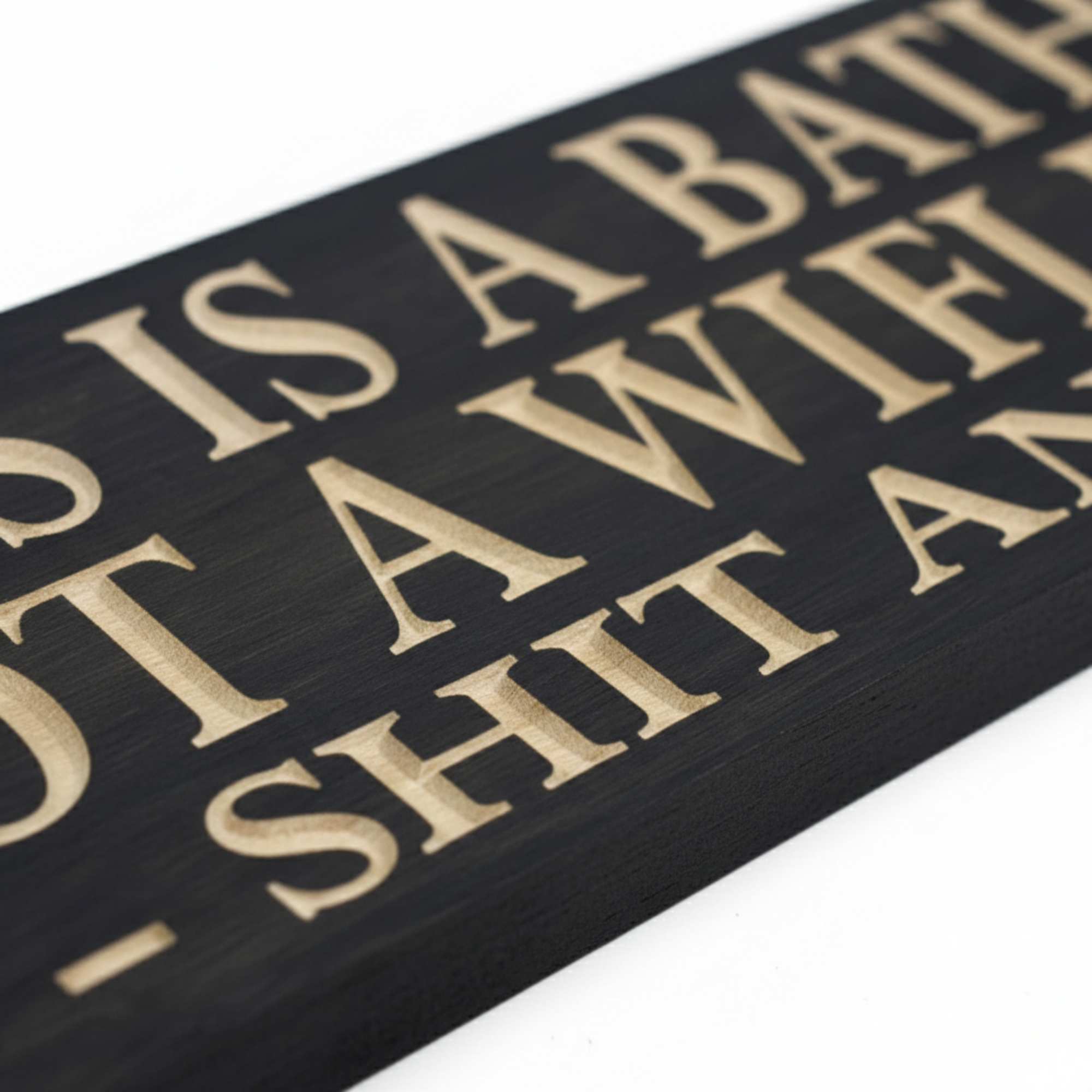 Close up view showing the 3D V-carve depth of the natural wood letters against the black stained surface of the Shit and Split sign.