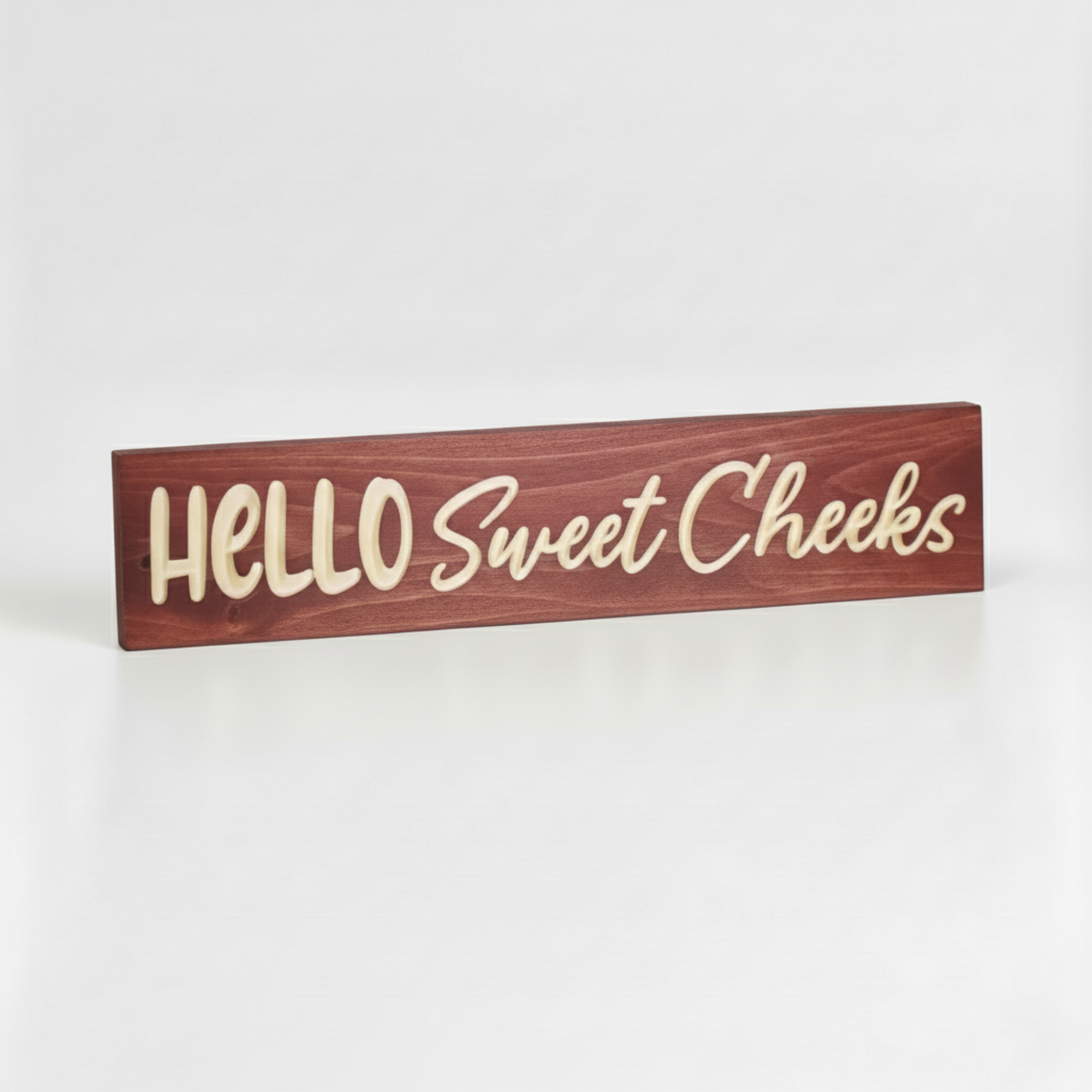 Perspective view of solid wood Hello Sweet Cheeks sign showing deep CNC V-carved lettering and natural wood grain.