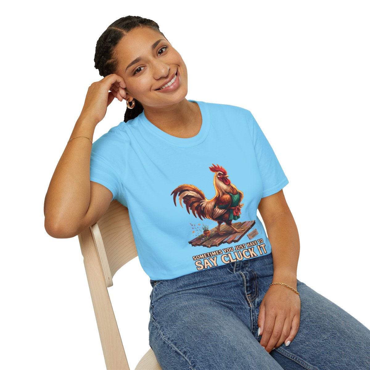 A woman sits smiling, leaning back in a light blue Chicken Shirt - Sometimes You Just Have to Say Cluck It, with jeans