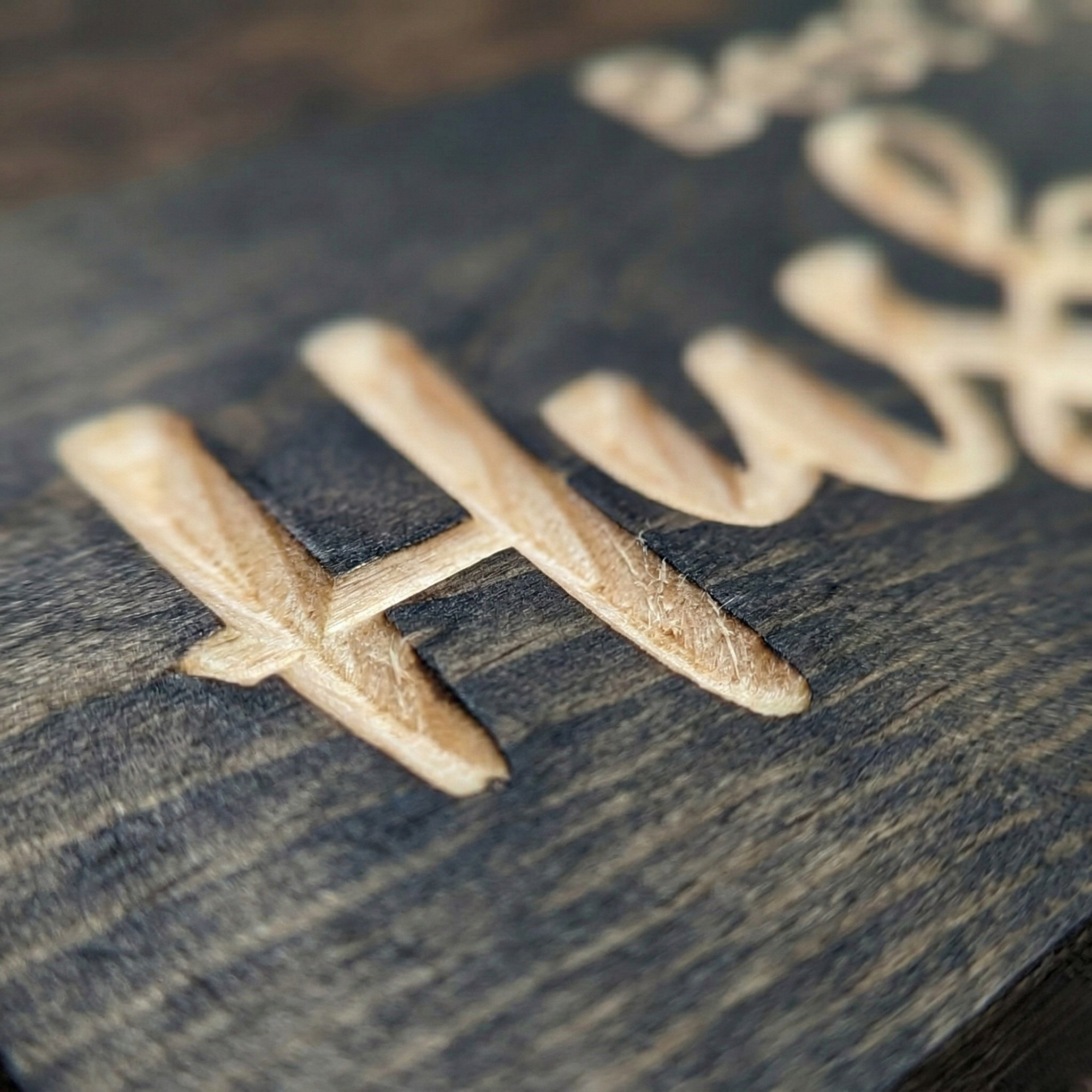 Close-up macro shot of the precision CNC carving on a Bluegrass Gifts wood sign, showing the deep 3D texture and natural American timber grain.