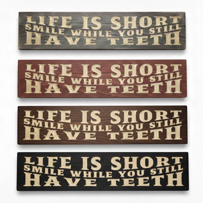 Four stacked "Life Is Short Smile" signs in Weathered Gray, Barn Red, Dark Walnut, and Ebony Black finishes on a white background.