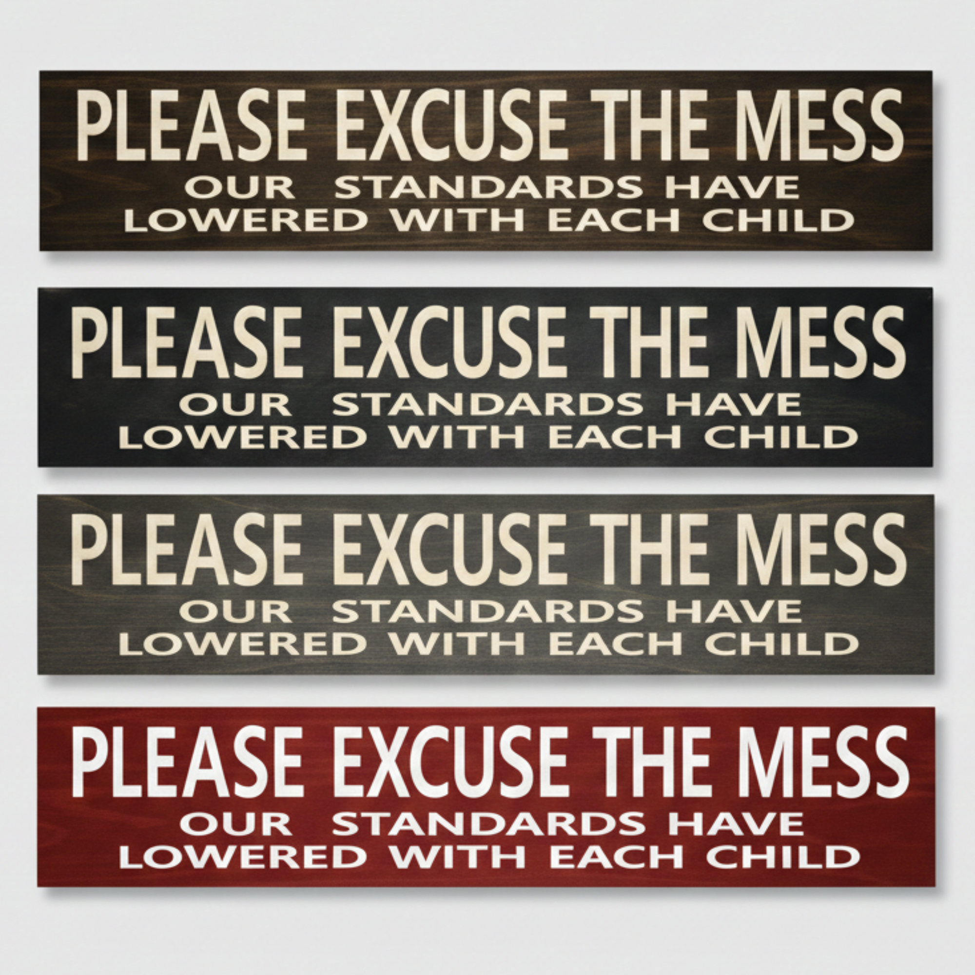 Four handcrafted wood signs in various finishes including Dark Walnut and Barn Red, all featuring the CNC-carved parenting humor quote about lowered standards.