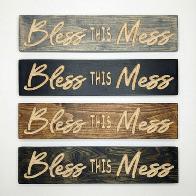 Stack of four carved wooden signs showing available stain finishes: Weathered Gray, Black, Early American, and Dark Walnut.