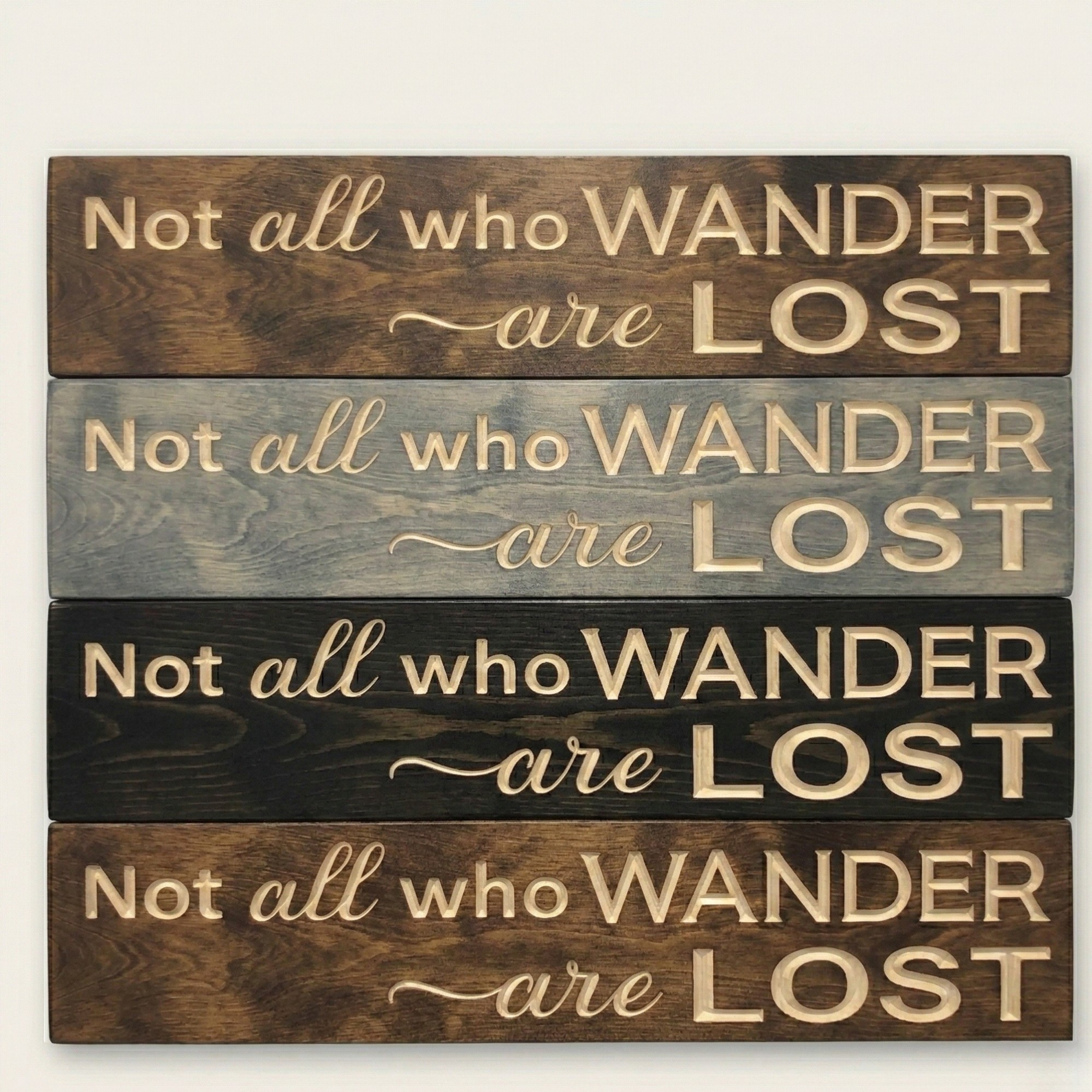 A stack of four "Not all who wander are lost" signs showing different finishes including Dark Walnut, Weathered Gray, and Natural.