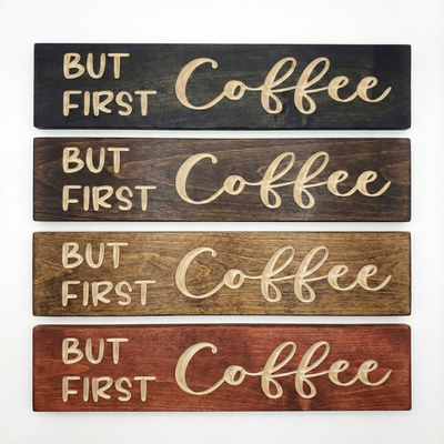 Stack of four "But First Coffee" signs showing available wood stain finishes: Ebony, Dark Walnut, Early American, and Barn Red.