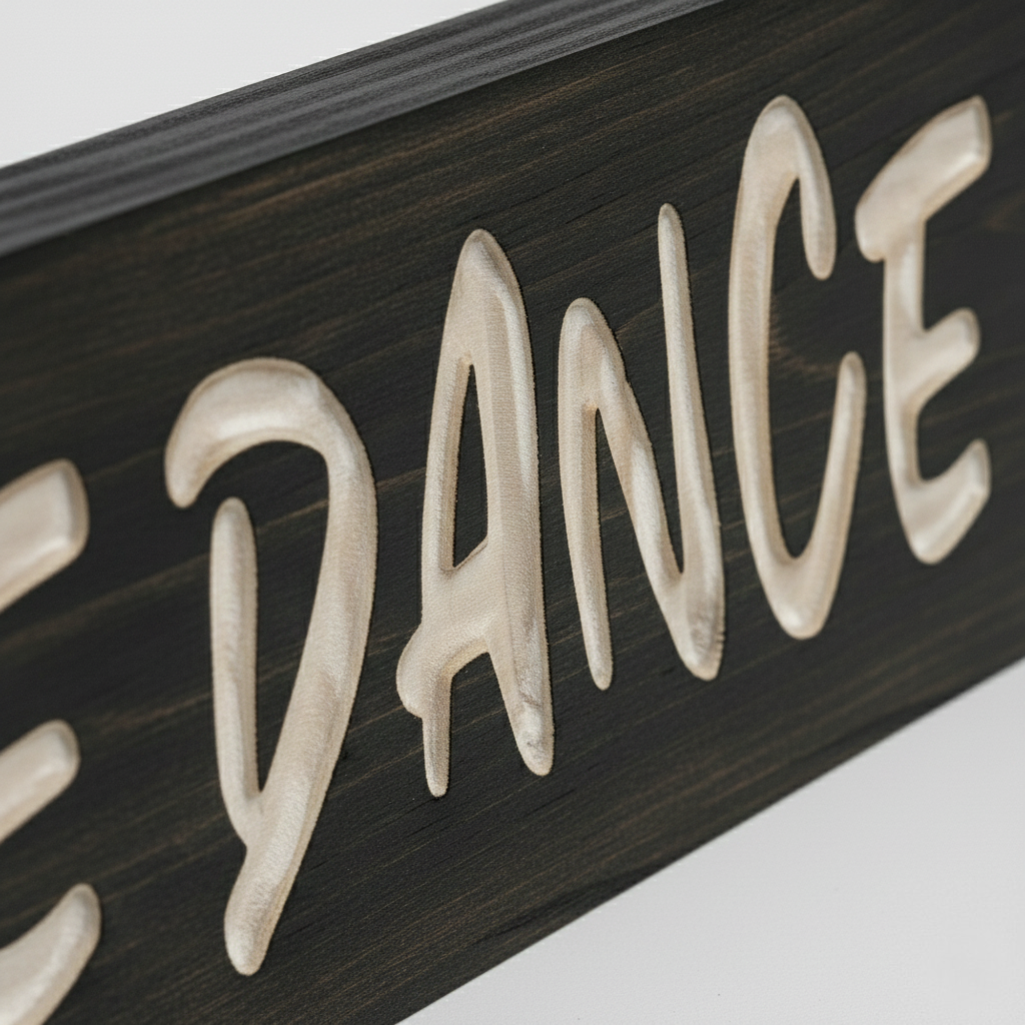 Macro close-up of the "DANCE" lettering showing the 3D relief and smooth texture of the CNC-carved solid wood from Bluegrass Gifts.