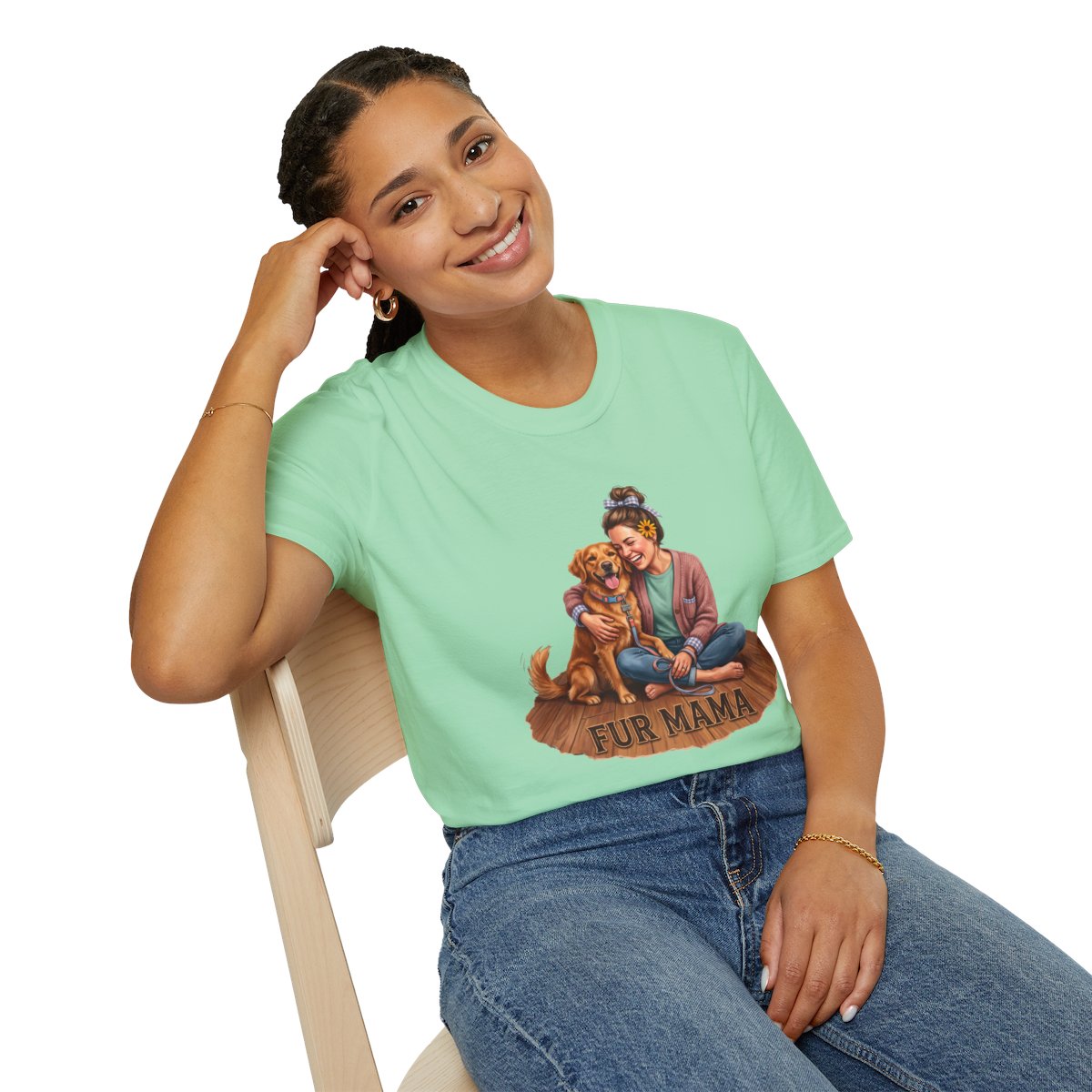 A smiling woman in a light green Dog Mom Shirt - Fur Mama, leaning back casually on a wooden chair from Bluegrass Gifts