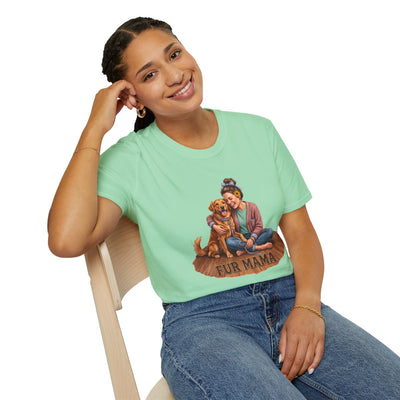 A smiling woman in a light green Dog Mom Shirt - Fur Mama, leaning back casually on a wooden chair from Bluegrass Gifts