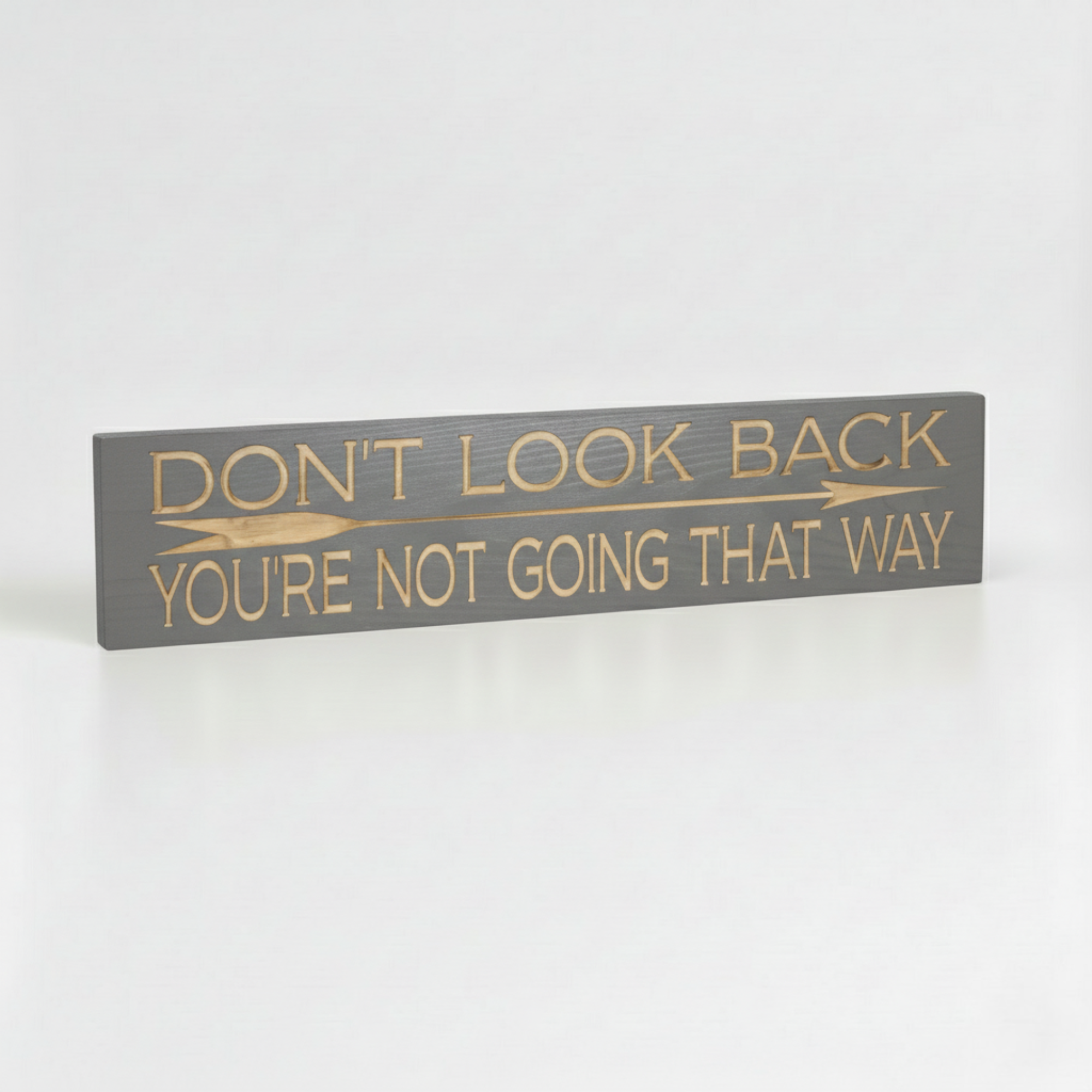 Angled view of the grey finished "Don't Look Back" motivational sign showing the solid wood thickness and premium CNC carving.