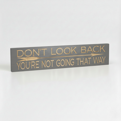 Angled view of the grey finished "Don't Look Back" motivational sign showing the solid wood thickness and premium CNC carving.