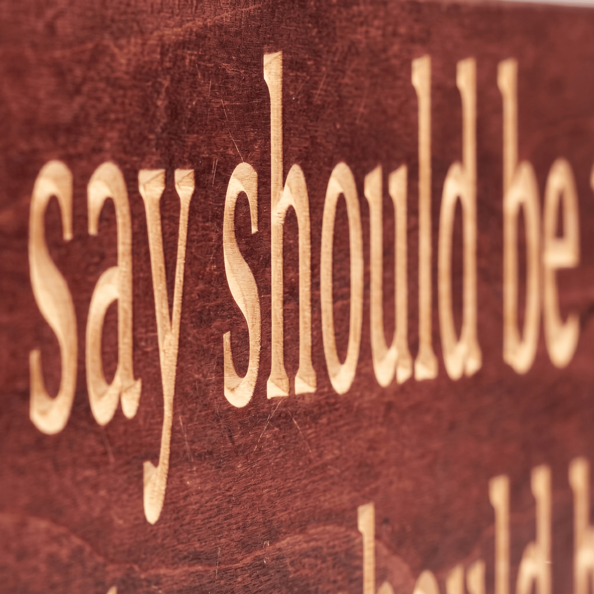 Close-up macro of deeply CNC-carved letters on the Everything You Say Should Be True wood sign showing dimensional 2.5D routing and natural grain through Cabernet stain