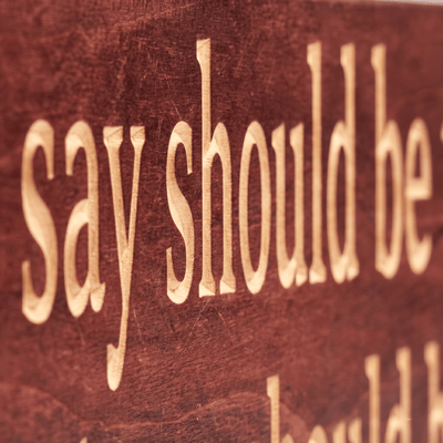 Close-up macro of deeply CNC-carved letters on the Everything You Say Should Be True wood sign showing dimensional 2.5D routing and natural grain through Cabernet stain