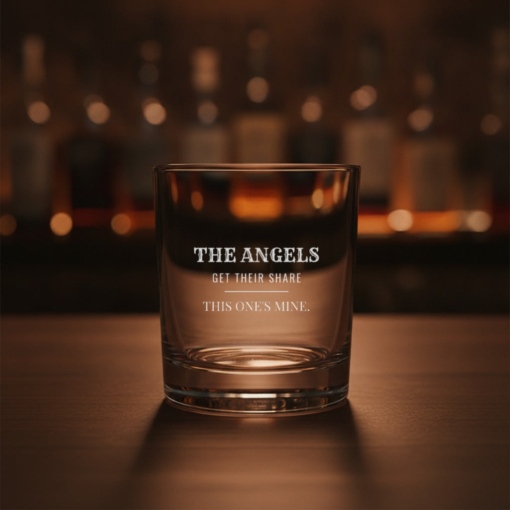 Engraved whiskey glass on a dark bourbon bar