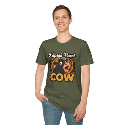 A man with short brown hair stands smiling, wearing an olive green Farmer Shirt - I Speak Fluent Cow with the full graphic