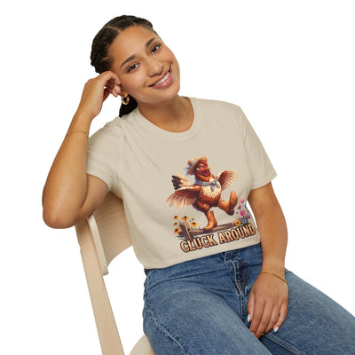A woman sits casually on a chair, smiling while wearing the light beige Chicken Shirt - Cluck Around with jeans