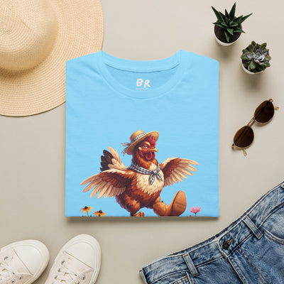 A folded light blue Chicken Shirt - Cluck Around is displayed flat with a straw hat, sunglasses, and jeans