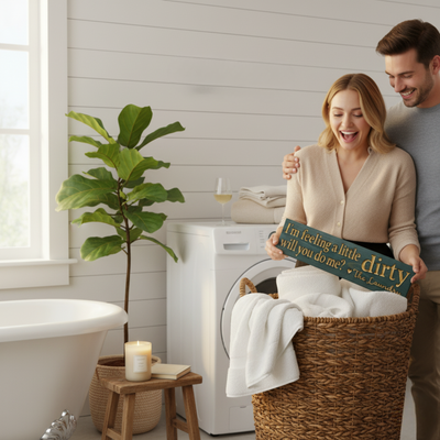 A woman laughing as her partner gives her a funny carved wood laundry room sign as a unique housewarming gift.
