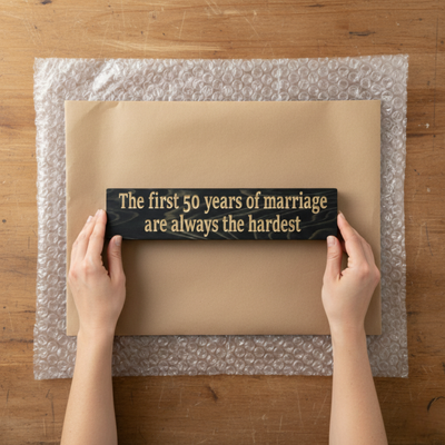 "A person holding a premium carved wood sign over gift-ready packaging, demonstrating the substantial size and quality feel."