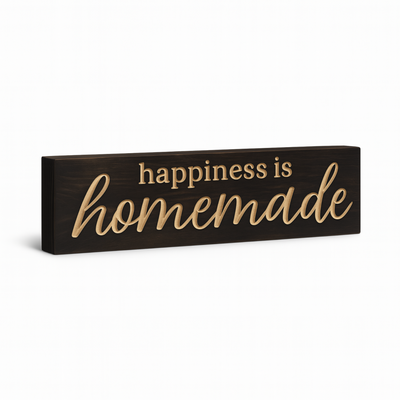 Angled view of the “happiness is homemade” CNC-carved solid wood sign on white background.