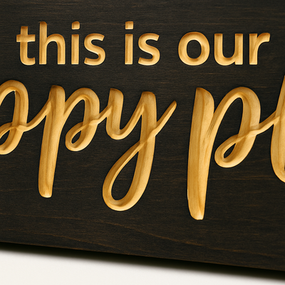 Close-up detail of carved lettering on This Is Our Happy Place wooden sign showing natural wood grain