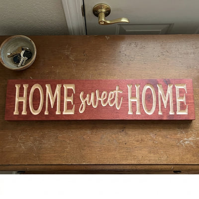 Overhead view of a red-stained Home Sweet Home Wooden Sign on a wooden table with keys in a bowl from Bluegrass Gifts
